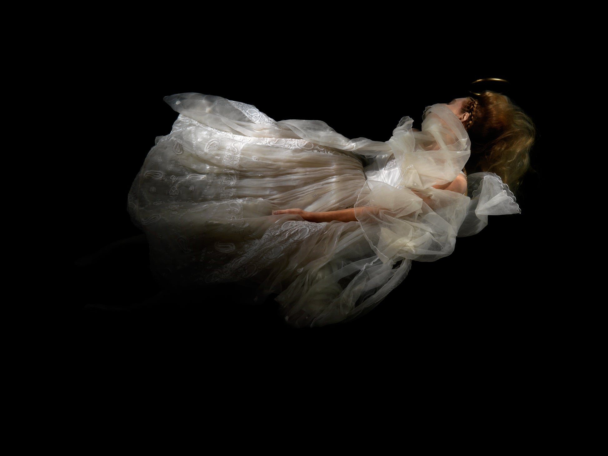 Unique archival pigment print of a woman in flowing white dress floating against black background.