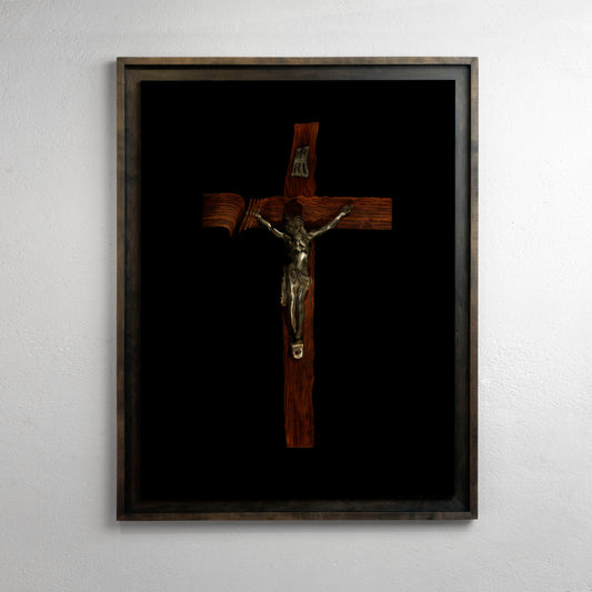 a traditional wood and bronze crucifix is photographed underwater presented in a museum frame
