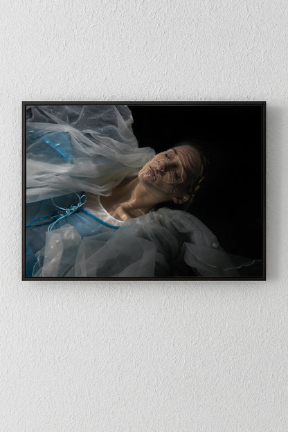 Unique archival pigment print of a woman draped in sheer fabric on black background.
