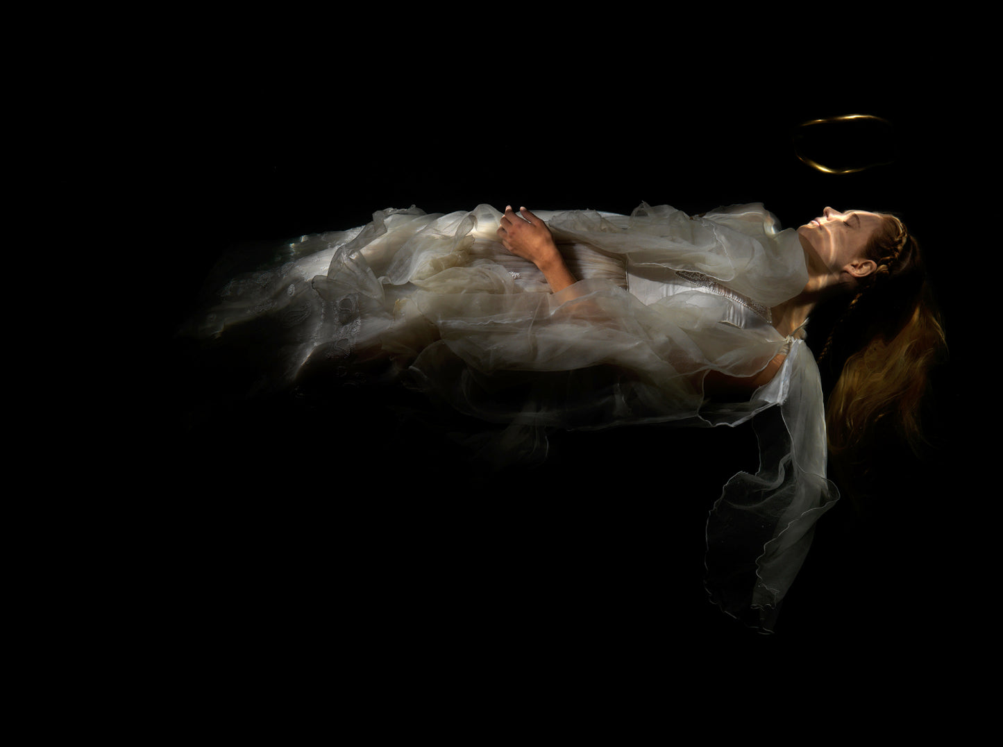 Unique archival pigment print of a reclining figure draped in sheer fabric against a black background.
