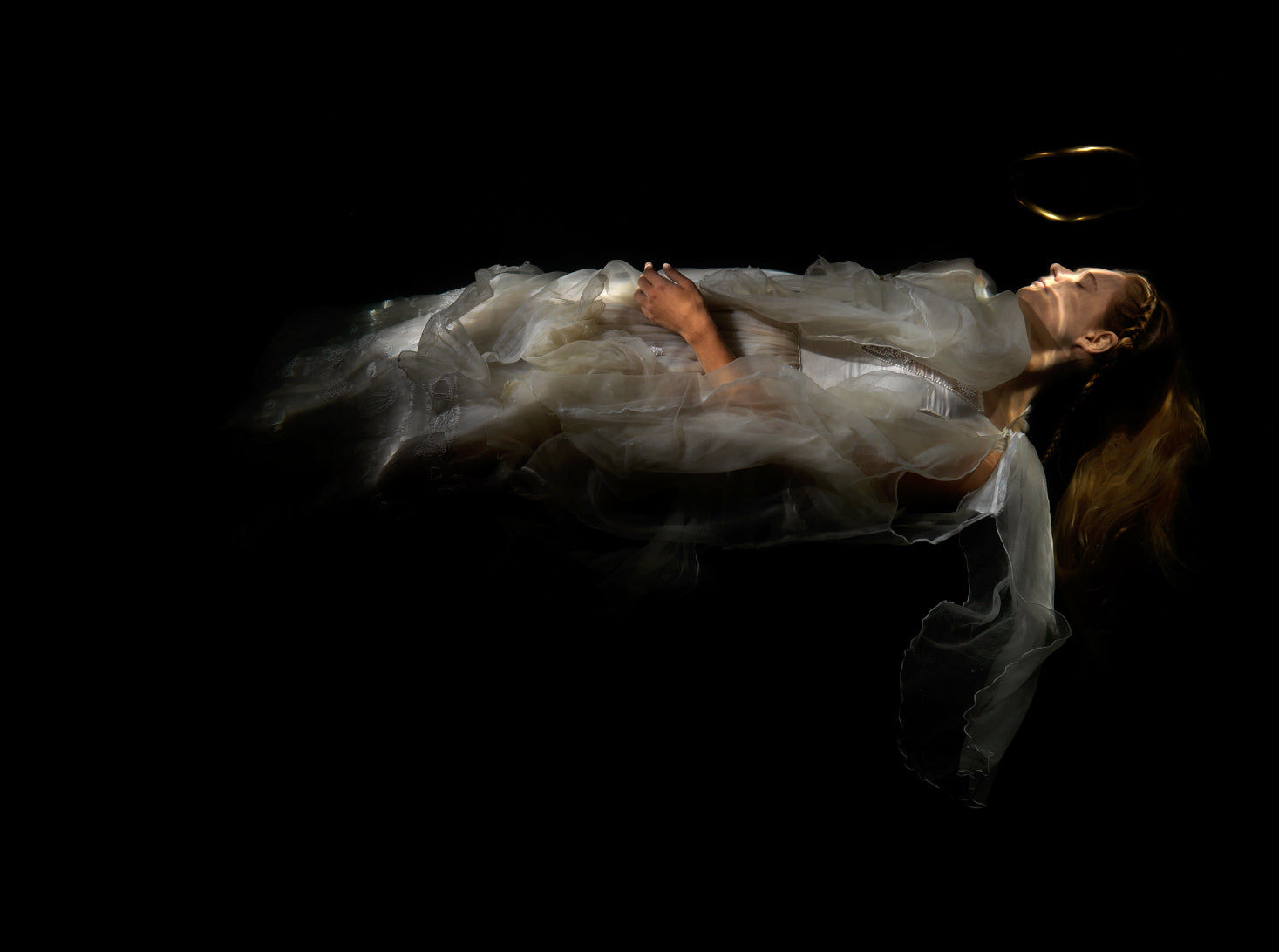 Unique archival pigment print of a reclining figure draped in sheer fabric against a black background.