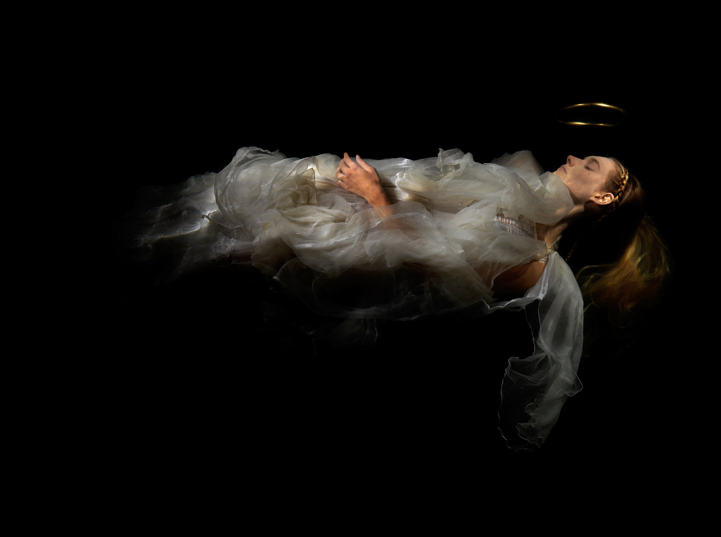 Ethereal portrait of woman in flowing white dress on unique archival pigment print with deep black background.