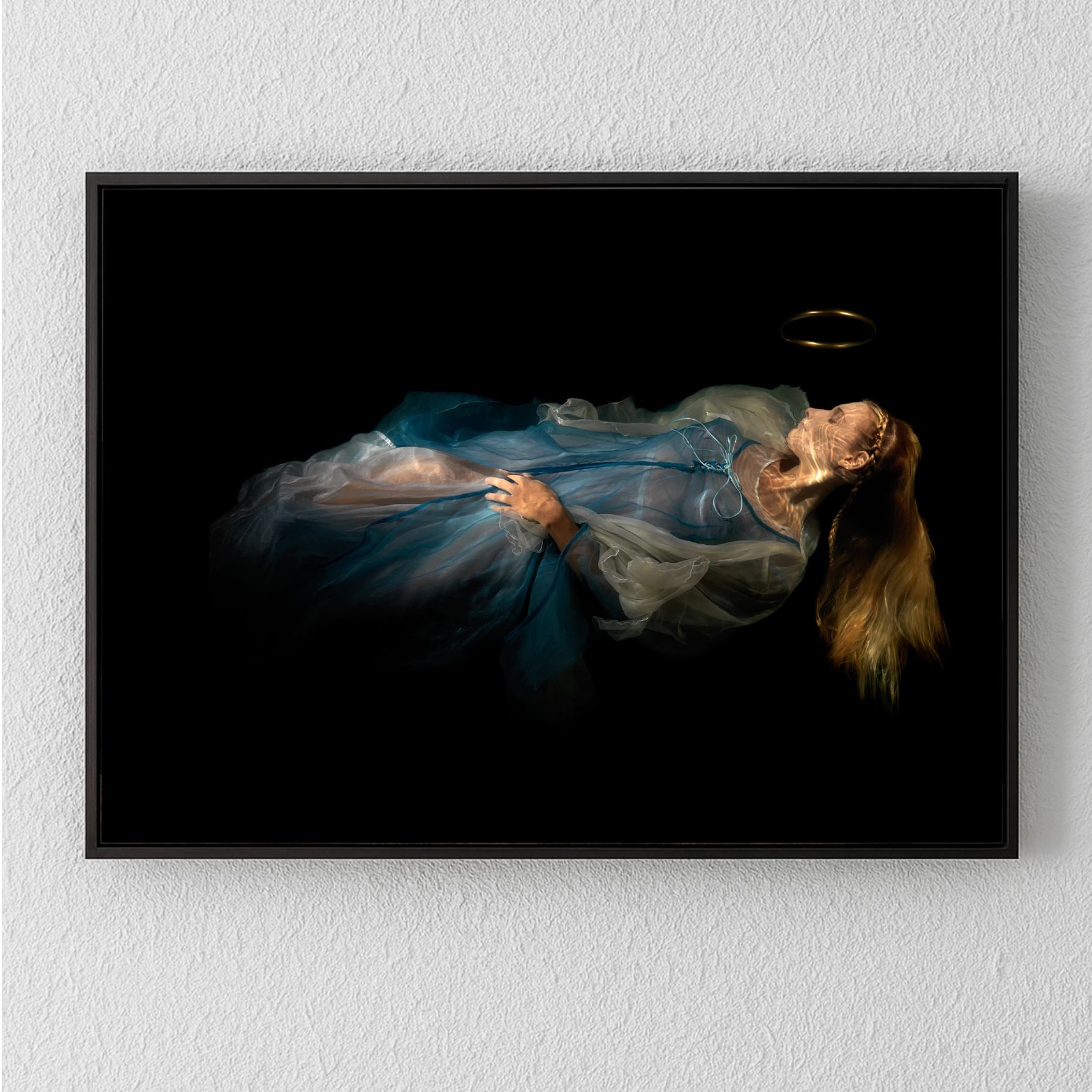 Unique archival pigment print of a woman in a flowing blue dress lying against a dark background.
