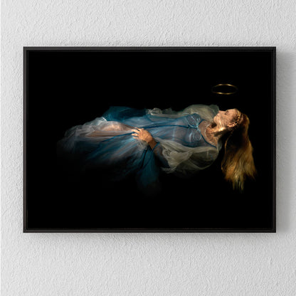 Unique archival pigment print of a woman in a flowing blue dress lying against a dark background.