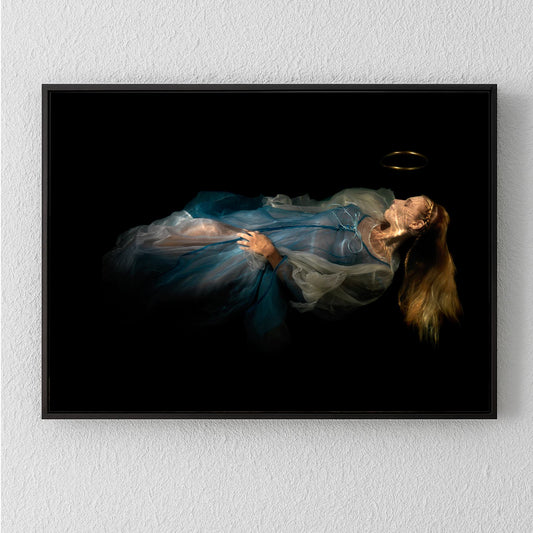Unique archival pigment print of a woman in a flowing blue dress lying against a dark background.
