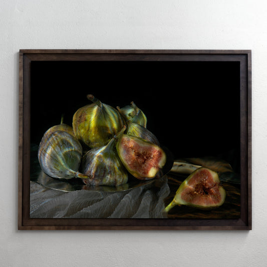 Framed artwork of figs on a reflective surface with a dark background
