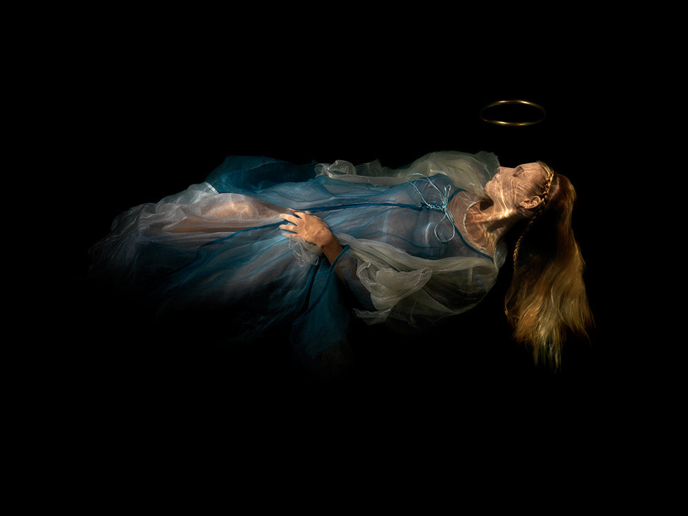 Unique archival pigment print of a woman reclining in a flowing blue dress against a dark background.